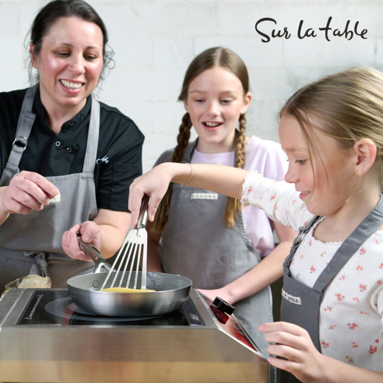 A woman and two children using Sur la Table cookware.