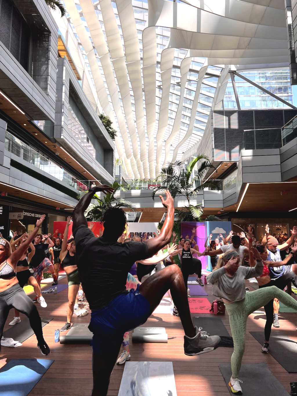 A fitness instructor leading a group workout in a mall.